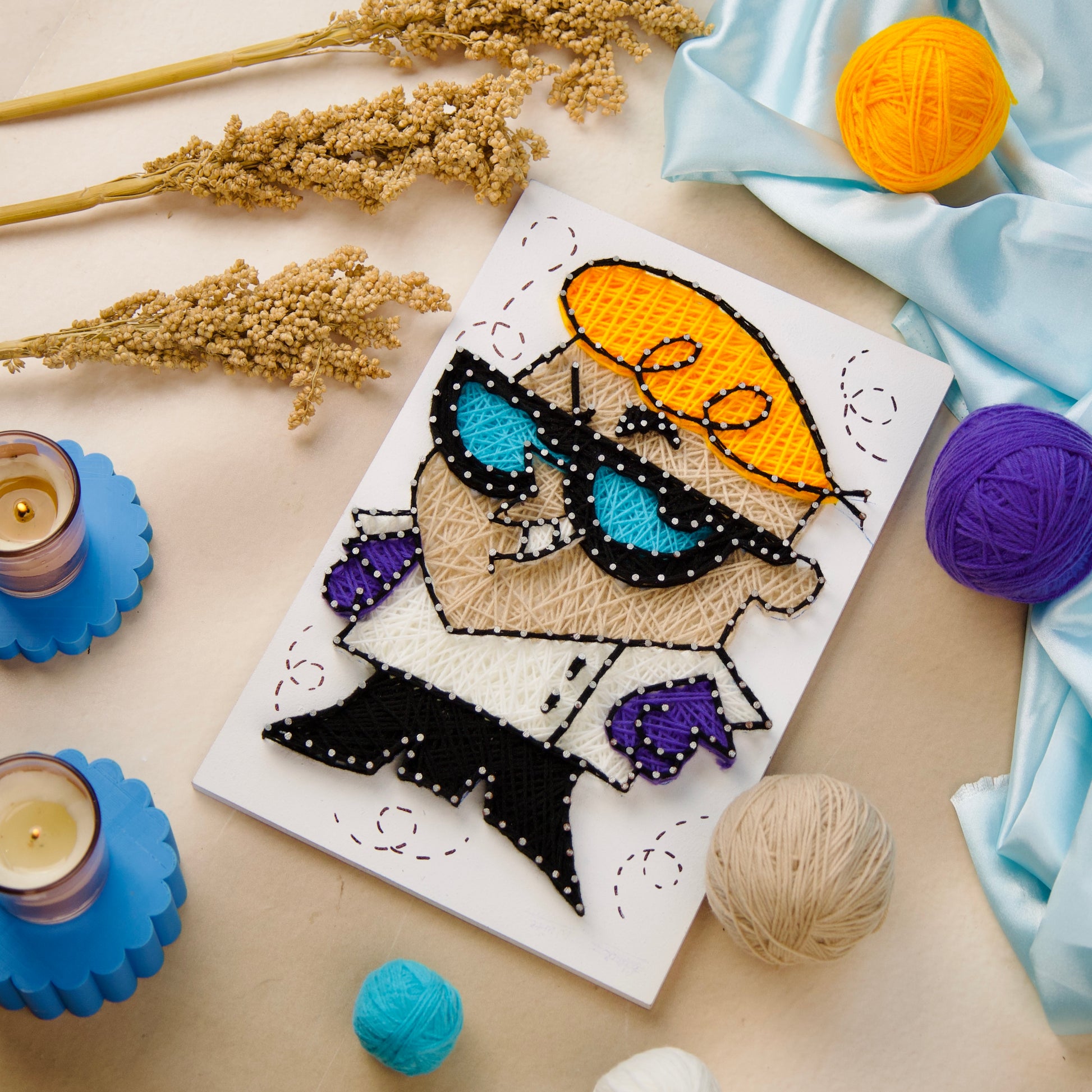 DIY string art featuring Dexter cartoon character with vibrant yarn on canvas – fun wall art for kids or collectors.