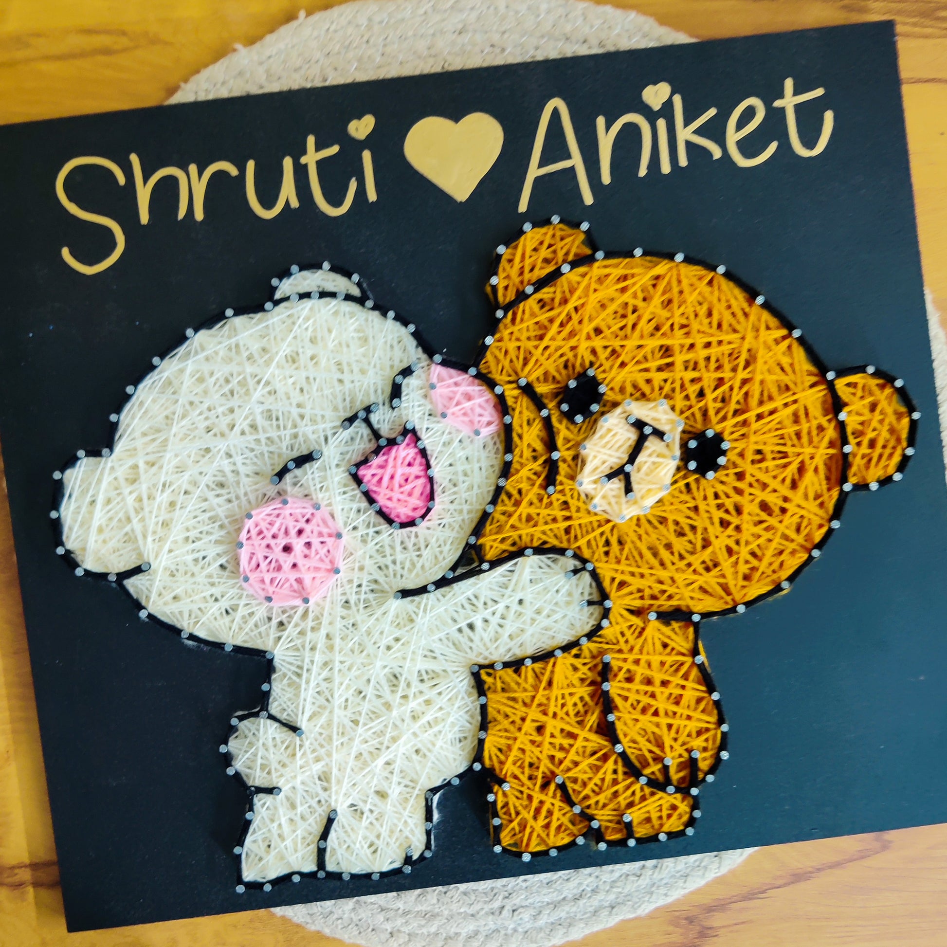 Handmade string art featuring two teddy bears hugging, perfect for customized gifts celebrating love and relationships.