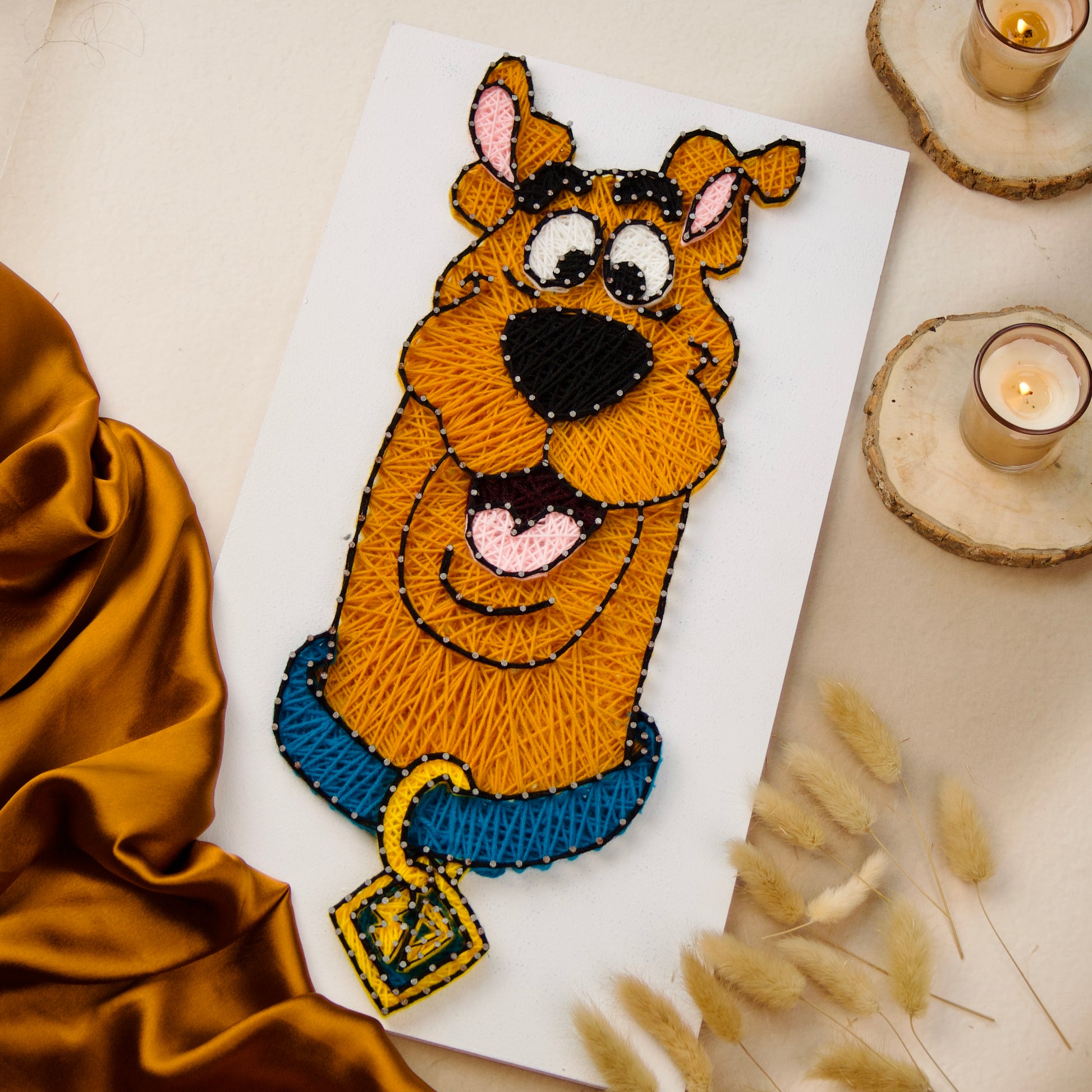 Scooby-Doo wall hanging made with string art technique, unique handmade piece for home or gifts.