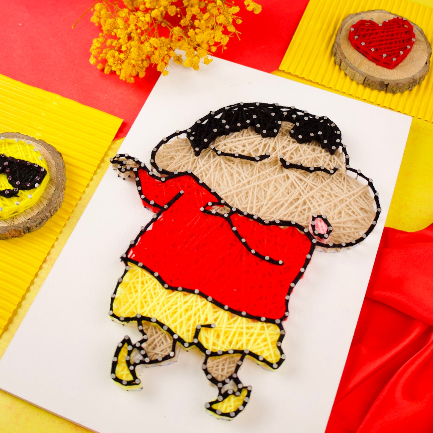 Colorful Shinchan string art on white board, quirky and fun décor for children’s spaces.
